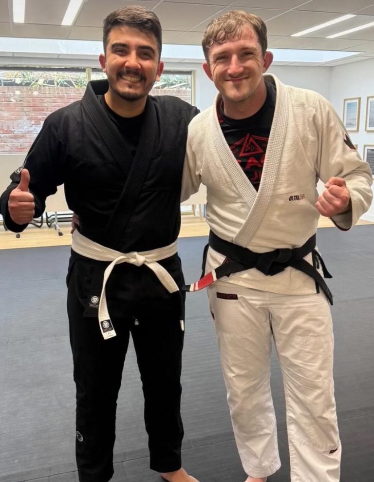 Mike taking a photo with one of the first True Virtues Jiu Jitsu whitebelts after the academy opened.